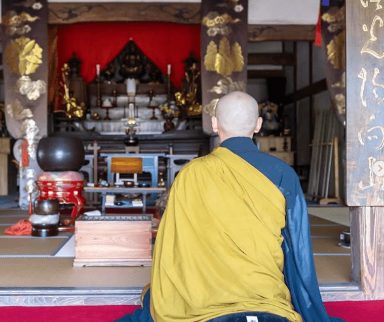 本堂で読経する都丸住職の後ろ姿